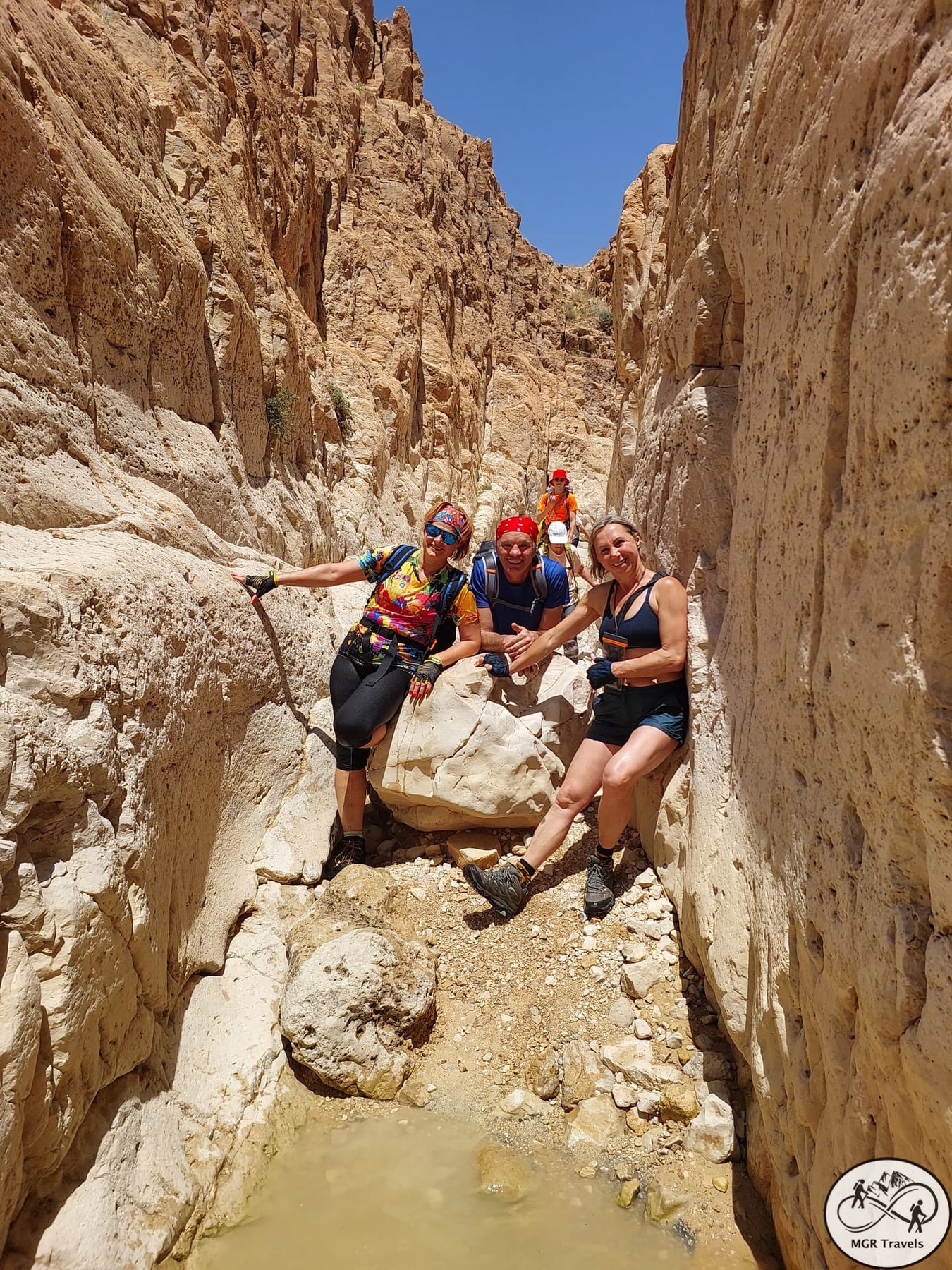 Friends on the rocks in a narrow sunlit canyon