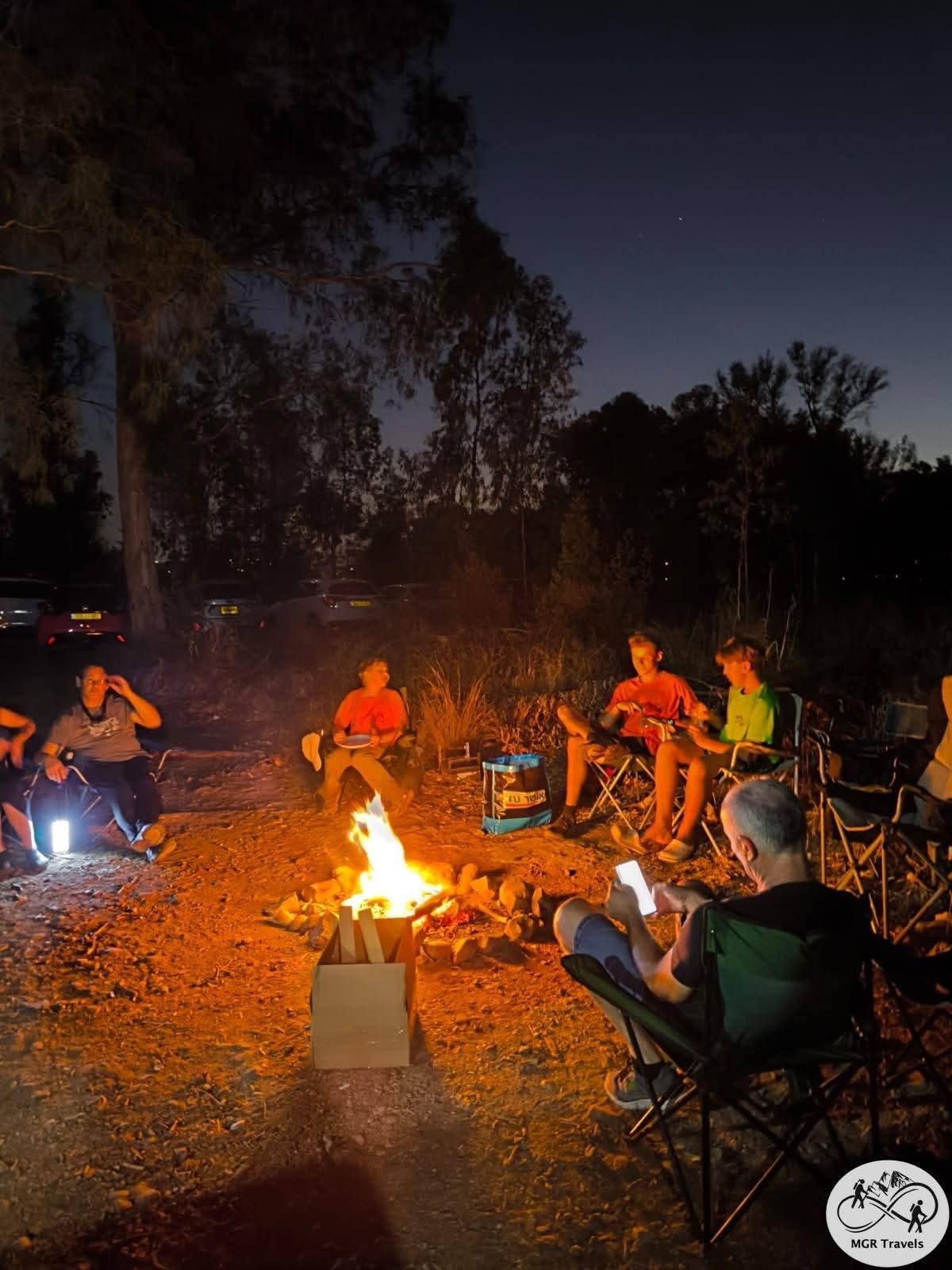 Friends gathered around a glowing evening campfire