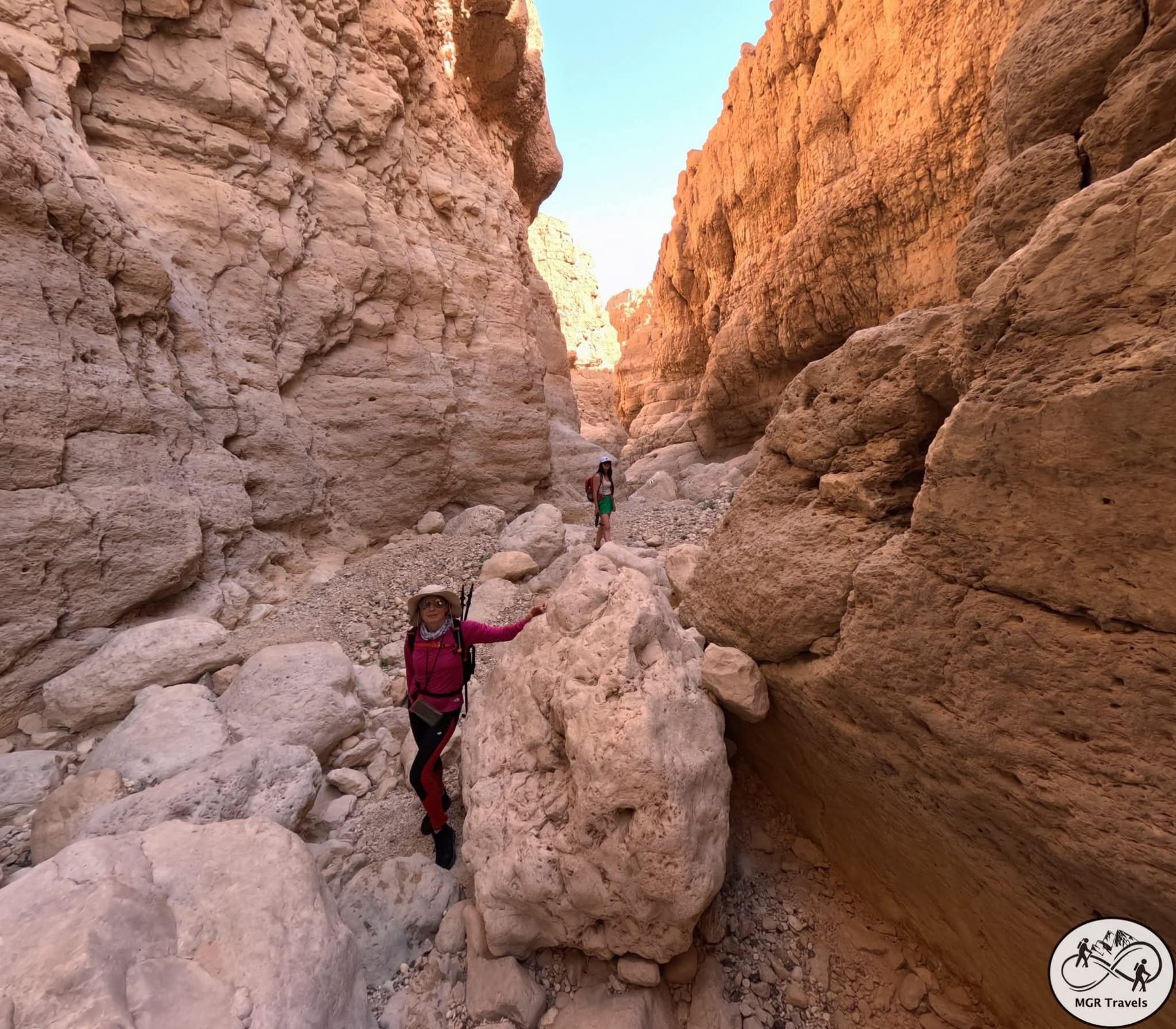 A hiker among the pink curves of a canyon